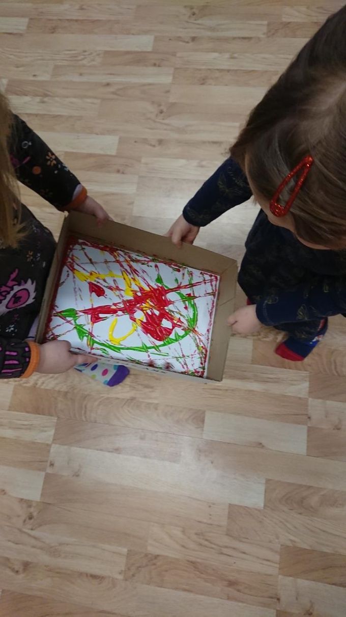 Här skapar barnen en teckning och samarbetar för att rulla kulan med över färgen